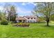 Charming two-story home with a large yard, mature trees, and manicured flower beds at 7440 Graham Rd, Indianapolis, IN 46250