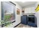 Well-lit laundry room with modern washer and dryer, white cabinets, and a bright window at 7440 Graham Rd, Indianapolis, IN 46250
