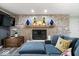 Comfortable living room with a stone fireplace, large TV, and a blue sectional sofa with decorative pillows at 7440 Graham Rd, Indianapolis, IN 46250