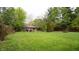 Green backyard with plenty of space featuring green grass, a wooden fence, and many trees at 8035 Black Oak Ct, Plainfield, IN 46168