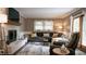 Cozy living room features a brick fireplace, a sectional couch and ample natural light at 8035 Black Oak Ct, Plainfield, IN 46168