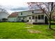 Beautiful backyard with lush lawn, mature tree, and a view of the home's exterior and screened porch at 8142 Bittern Ln, Indianapolis, IN 46256