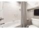 Clean bathroom features a bathtub with white tiled walls and a stylish, striped shower curtain at 8142 Bittern Ln, Indianapolis, IN 46256