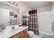Bright bathroom featuring wood cabinets and a shower with brown curtains at 8410 Glenwillow Ln # 208, Indianapolis, IN 46278