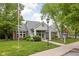 Community clubhouse with manicured lawn, trees, and an American flag at 8410 Glenwillow Ln # 208, Indianapolis, IN 46278