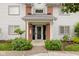 Charming condo entrance with brick accents, manicured landscaping, and a welcoming covered doorway at 8410 Glenwillow Ln # 208, Indianapolis, IN 46278