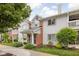 Attractive condo building featuring gray siding, brick accents, and well-maintained landscaping with colorful flowers at 8410 Glenwillow Ln # 208, Indianapolis, IN 46278