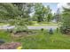 Landscaped front yard with lush lawn and mature trees across from a quiet, well-maintained street at 8410 Glenwillow Ln # 208, Indianapolis, IN 46278