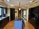 Modern kitchen with a large island, black cabinets, granite countertops, and wood flooring at 8502 Jib Ct, Indianapolis, IN 46236