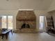 Spacious living room with a brick fireplace, large windows, and neutral tile flooring at 8502 Jib Ct, Indianapolis, IN 46236