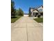 Long concrete driveway leading to a detached garage and a beautiful two-story home at 8830 Kipling Dr, Indianapolis, IN 46239