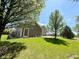 View of home's side yard, featuring a grassy lawn and mature trees at 8830 Kipling Dr, Indianapolis, IN 46239