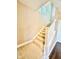 Carpeted staircase with white railings and natural light, offering a warm welcome to the upper level at 8830 Kipling Dr, Indianapolis, IN 46239