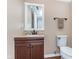 Half bathroom featuring a vanity with stone countertop and a framed mirror at 9162 Cinnebar Dr, Indianapolis, IN 46268