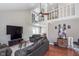 Open-concept living room featuring a ceiling fan, a second level loft, hardwood floors, and a comfortable seating arrangement at 9162 Cinnebar Dr, Indianapolis, IN 46268