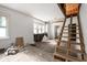 Renovation-ready living room featuring large windows and unfinished staircase at 940 N Chester Ave, Indianapolis, IN 46201