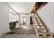 Bright living room with natural light, unfinished staircase, ready for renovation at 940 N Chester Ave, Indianapolis, IN 46201