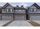 Modern townhome exterior showcasing stylish gray siding, dark trim, and convenient attached two-car garages at 9734 Behner Dr, Fishers, IN 46250