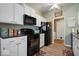 Well-lit kitchen showcasing black appliances, white cabinets, and modern flooring at 1002 Prairie Depot, Indianapolis, IN 46241