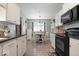 Charming kitchen with white cabinets, black appliances, and a cozy dining area at 1002 Prairie Depot, Indianapolis, IN 46241