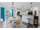Open dining area with a view of the kitchen, featuring wood floors and modern lighting at 1040 Iowa St, Columbus, IN 47201