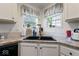 The kitchen features a corner sink with white cabinets, dark hardware, and bright natural light at 1040 Iowa St, Columbus, IN 47201