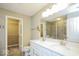 Bright bathroom featuring double sink vanity, large mirror, tile floors, and walk-in closet at 10448 Pintail Ln, Indianapolis, IN 46239
