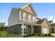 Angle view of a two-story home with brick and siding exterior, a covered porch, and manicured landscaping at 10448 Pintail Ln, Indianapolis, IN 46239