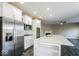 Modern kitchen with stainless steel appliances, an island, and a view into the living room at 10448 Pintail Ln, Indianapolis, IN 46239
