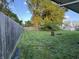 Fenced backyard with green grass and mature trees offers privacy and space for outdoor enjoyment at 107 N Grant St, Brownsburg, IN 46112