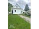 A backyard of a single-Gathering home with mature trees and an unpaved driveway at 11 W Osage St, Greenfield, IN 46140