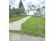 A backyard of a single-Gathering home with mature trees and an unpaved driveway at 11 W Osage St, Greenfield, IN 46140