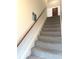 Carpeted staircase with wooden handrail and access to the upper level at 11 W Osage St, Greenfield, IN 46140
