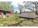 Manicured backyard featuring green grass, storage shed, and partial view of brick home at 1101 Oakwood Trl, Indianapolis, IN 46260