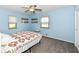 Cozy bedroom featuring soft blue walls, a ceiling fan, and plush gray carpeting at 1101 Oakwood Trl, Indianapolis, IN 46260