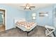 Bright bedroom featuring soft blue walls, ceiling fan, and plush gray carpet at 1101 Oakwood Trl, Indianapolis, IN 46260