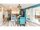 Stylish dining room features modern table, blue chairs, and open view to the kitchen, perfect for gatherings at 1101 Oakwood Trl, Indianapolis, IN 46260