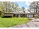 Charming brick ranch home featuring an attached garage and well-manicured lawn at 1101 Oakwood Trl, Indianapolis, IN 46260
