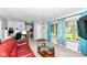Cozy living room featuring large windows with blue curtains and a red leather couch at 1101 Oakwood Trl, Indianapolis, IN 46260
