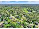 Lush aerial view of a residential area dotted with mature trees and featuring a nearby green golf course at 12669 Brookshire Pkwy, Carmel, IN 46033