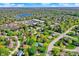 Beautiful aerial view showcasing a suburban neighborhood with mature trees, nearby shopping, and a peaceful lake at 12669 Brookshire Pkwy, Carmel, IN 46033