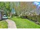 Manicured backyard with a pathway, lush lawn, mature trees, and a glimpse of the pool at 12669 Brookshire Pkwy, Carmel, IN 46033