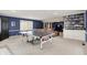 A spacious game room with a ping pong table, built-in shelving, and a media center in the background at 12669 Brookshire Pkwy, Carmel, IN 46033