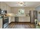 Bright kitchen featuring white cabinets, stainless steel appliances, and a view of the backyard, perfect for cooking at 12669 Brookshire Pkwy, Carmel, IN 46033