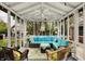 Enclosed sunroom with comfortable seating and an exterior view of the pool and backyard at 12669 Brookshire Pkwy, Carmel, IN 46033