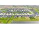 An aerial view shows a neighborhood with many houses and green lawns around a body of water at 1295 Clairet Dr, Westfield, IN 46074