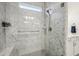 Close up of marble tiled shower with glass enclosure, rainfall shower head, and built-in bench at 1295 Clairet Dr, Westfield, IN 46074