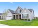 Charming two-story home featuring a stone column porch, gabled roof, and well-manicured lawn at 1295 Clairet Dr, Westfield, IN 46074