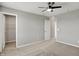 A serene bedroom featuring neutral walls, carpet, trim and a ceiling fan light, with doors to a closet and hallway at 12951 Corydon Dr, Fishers, IN 46037