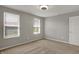 A light bedroom featuring neutral walls, carpet, trim and two windows that provide ample natural light at 12951 Corydon Dr, Fishers, IN 46037